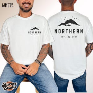 May include: White t-shirt with a black mountain graphic and the word "NORTHERN" printed on the front and back. The front graphic includes the text "EST. X 2007". The back graphic is a larger version of the mountain design with the same text. The shirt is a casual style.