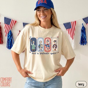 May include: Ivory t-shirt with a patriotic goose design. The graphic shows four geese in patriotic outfits, with the text "Just a patriotic goose". The shirt is a Comfort Colors brand.