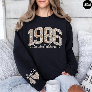May include: Black sweatshirt with the year "1986" in a floral design. The words "limited edition" are below the year. The left sleeve has the words "chapter 4" and a floral heart design. The sweatshirt is a limited edition.
