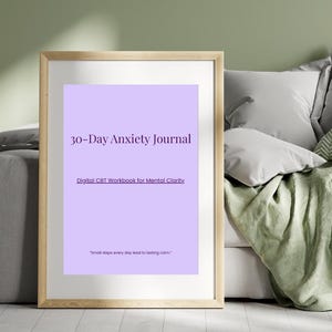 Può includere: Una stampa incorniciata con sfondo lilla chiaro. Il testo recita "30-Day Anxiety Journal" e "Digital CBT Workbook for Mental Clarity." Sotto, c'è scritto "Small steps every day lead to lasting calm."