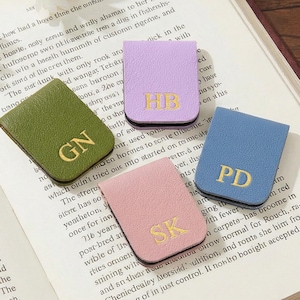 以下が含まれることがあります： 黒い持ち手と「But First, Coffee」の文字が黒い太字でプリントされた白いセラミックマグ。 マグカップは木製の表面に置かれています。 マグカップの高さは約10cmです。