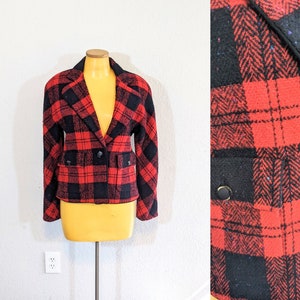 Może przedstawiać: Czarno-czerwony pikowany blazer zapinany na guziki. Blazer ma wzór w jodełkę i jest wykonany z miękkiej, fakturowanej tkaniny.