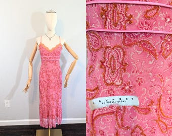 May include: A pink, beaded, sleeveless maxi dress with a paisley pattern. The dress has a label that reads "Laundry by Shelli Segal".