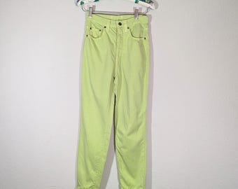 May include: A pair of high-waisted, lime green jeans hanging on a floral-patterned hanger. The jeans have a classic five-pocket design and a straight leg. The pants are made of a solid-colored, lightweight fabric.