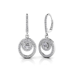 Puede incluir: Un par de pendientes plateados con un diseño circular. Cada pendiente presenta una piedra preciosa central, redonda y transparente, rodeada por un halo de piedras más pequeñas. El círculo exterior también está incrustado con pequeñas piedras transparentes.