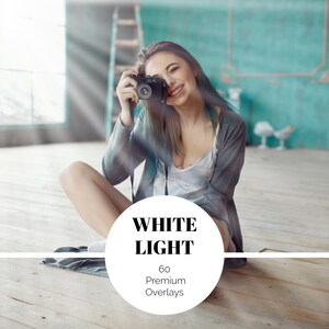 Peut inclure: Une personne souriante tenant un appareil photo noir, assise sur un sol en bois. L'image comprend le texte "WHITE LIGHT" et "60 Premium Overlays" dans un cercle blanc. L'arrière-plan présente un mur turquoise et une échelle en bois.