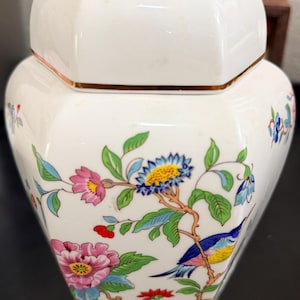Peut inclure: Ensemble de trois mugs en céramique crème tachetée. Chaque mug présente un motif peint à la main différent : une feuille bleue et verte, une fleur jaune et une baie rouge. Les mugs ont une forme simple et arrondie.