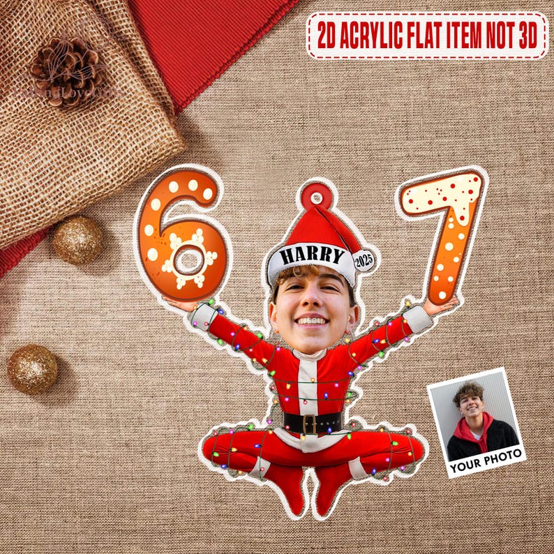 May include: A festive acrylic decoration featuring a person's face in a Santa Claus outfit, holding the numbers 6 and 7. The decoration is adorned with string lights and the text "2D ACRYLIC FLAT ITEM NOT 3D". A small photo is included with the text "YOUR PHOTO".