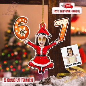 May include: A personalized Christmas ornament featuring a photo of a person dressed in a Santa Claus outfit, holding the numbers 6 and 7. The ornament includes the name "SOPHIA" and the year "2025". The text "2D ACRYLIC FLAT ITEM NOT 3D" is also visible.