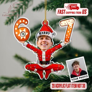 May include: A personalized Christmas ornament featuring a person's face in a Santa Claus outfit, holding the numbers 6 and 7. The ornament has the name "HARRY" and the year "2025" on a Santa hat. The text "YOUR PHOTO" is also visible.