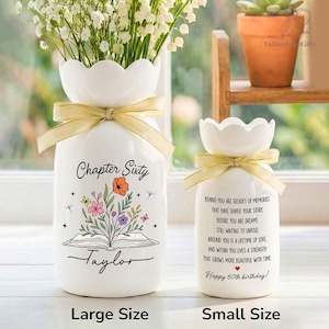 May include: Two white ceramic vases with scalloped rims and gold ribbons. The larger vase features a book illustration with flowers and the text "Chapter Sixty Taylor". The smaller vase displays a printed birthday message and a small red heart.