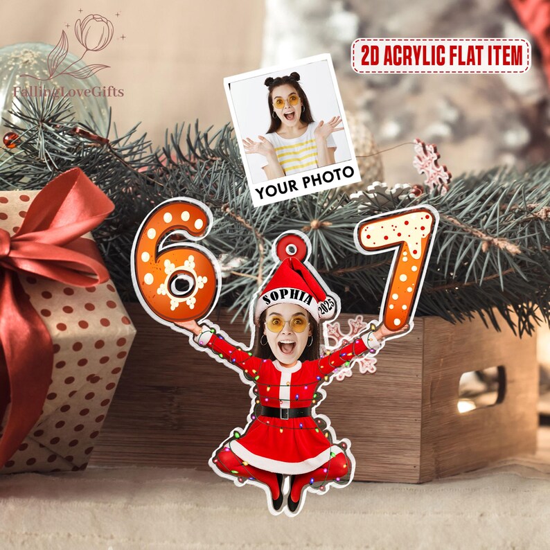 May include: A personalized Christmas ornament featuring a photo and the numbers 6 and 7. The ornament shows a person in a Santa Claus outfit holding the numbers. The text "YOUR PHOTO" is above the photo. The text "2D ACRYLIC FLAT ITEM" is in the upper right corner.