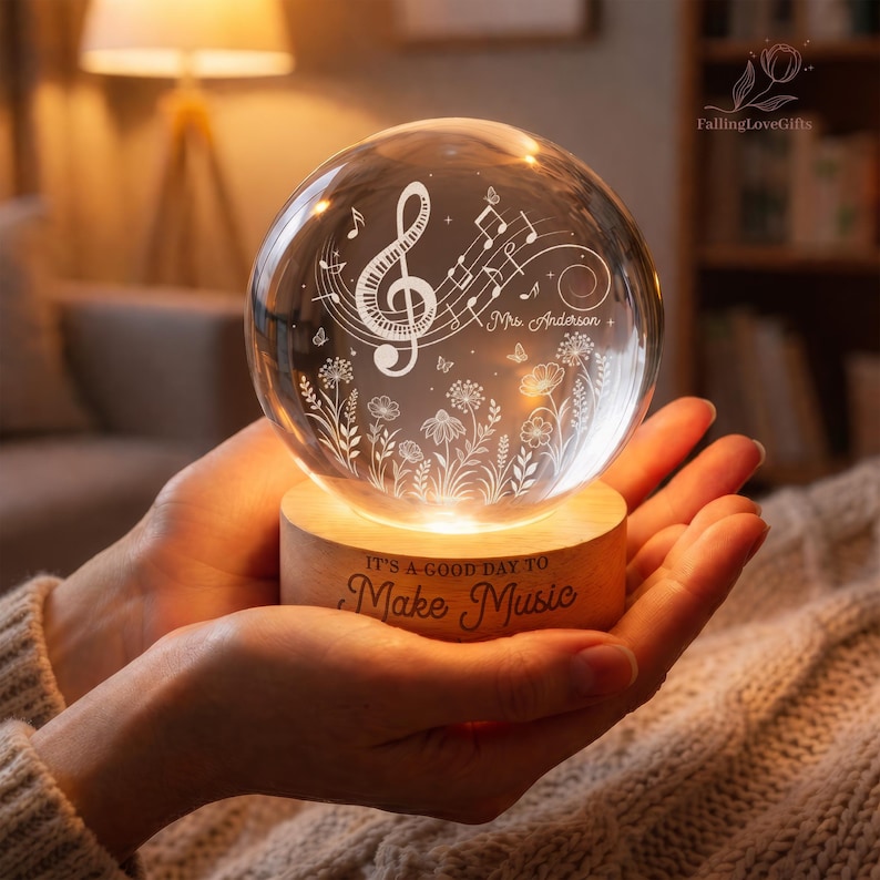 Pu&ograve; includere: Una sfera di vetro trasparente con un design a nota musicale, appoggiata su una base di legno. La base &egrave; incisa con la frase "IT'S A GOOD DAY TO Make Music". La sfera &egrave; illuminata, creando un bagliore caldo.