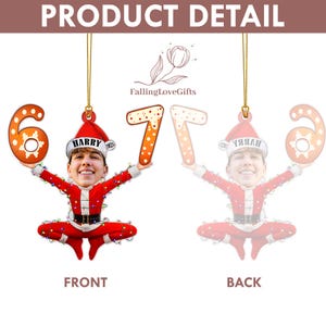 May include: A Christmas ornament featuring a person's face wearing a Santa hat, holding the numbers 6 and 7. The ornament is red and white, with a gold string for hanging. The text "HARRY 2023" is on the hat.