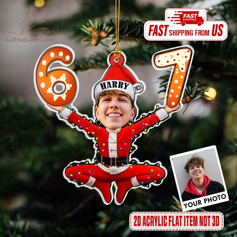May include: A personalized Christmas ornament featuring a photo of a person dressed as Santa Claus, holding the numbers 6 and 7. The ornament is red and white, with the name "HARRY" on the hat. The text "2025" is also on the hat. The ornament is hanging on a Christmas tree.