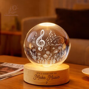 Pu&ograve; includere: Una sfera di vetro illuminata con note musicali e motivi floreali, posta su una base di legno. La base recita "IT'S A GOOD DAY TO Make Music". La sfera si illumina dall'interno, creando un'atmosfera calda. Un bel regalo per gli amanti della musica.