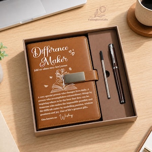 May include: A brown leather journal with the text "Difference Maker" and a definition, presented in a gift box with a pen and a stylus. The journal has a silver clasp and a floral design.
