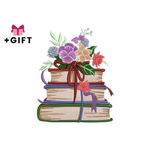 Op de afbeelding: Een geborduurd ontwerp met een stapel boeken versierd met linten en bekroond met een bloemstuk. De bloemen omvatten paarse viooltjes, rode en perzikbloesems en groene bladeren. De tekst "+CADEAU" staat naast een roze geschenkdoos.