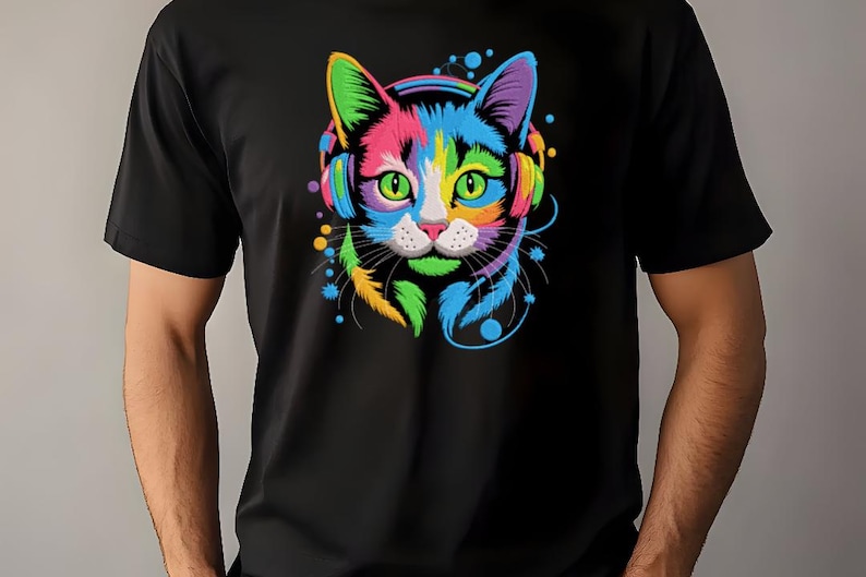 A person wearing a black t-shirt with a colorful, vibrant graphic of a cat's face and ears, along with a pair of headphones.