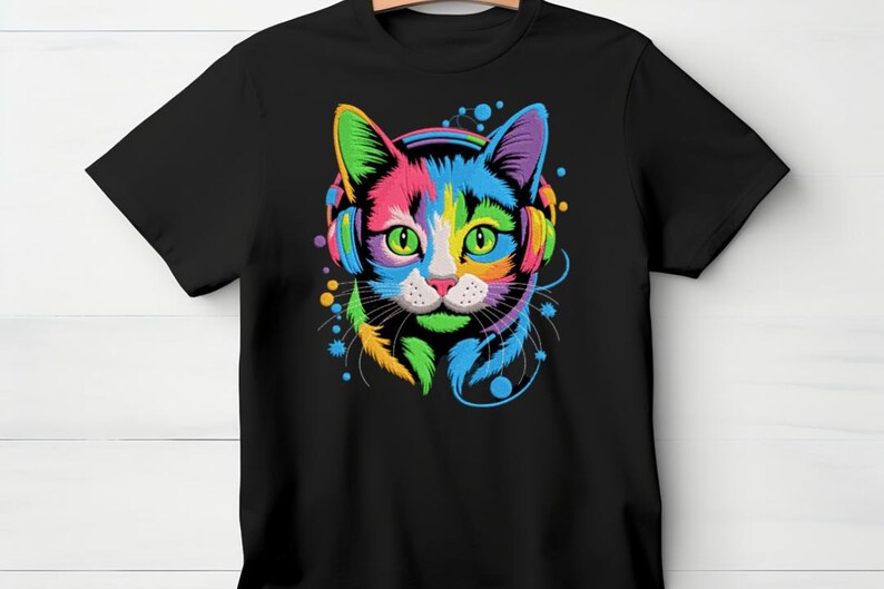 A black t-shirt with a colorful, vibrant graphic of a cat's face wearing headphones, surrounded by various colorful elements.