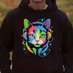 A person wearing a black hoodie with a colorful, multicolored cat design on the front.
