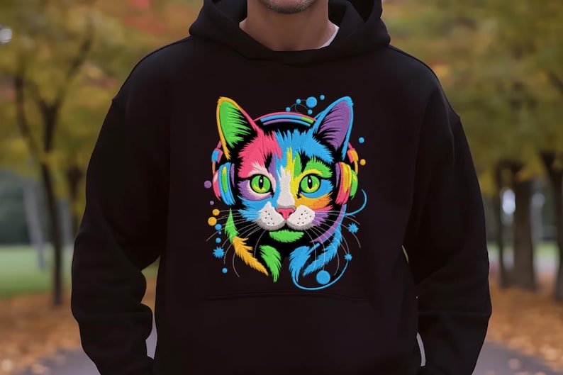 A person wearing a black hoodie with a colorful, multicolored cat design on the front.