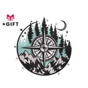 Può includere: Design ricamato con una rosa dei venti, montagne, pini e una luna crescente. Il design è ambientato all'interno di un cerchio con uno sfondo azzurro chiaro e bianco. Il testo "+REGALO" è sopra il design.