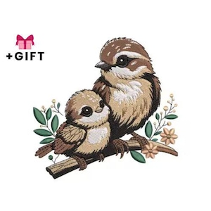 Könnte beinhalten: Ein gesticktes Design mit zwei Vögeln auf einem Ast mit Blättern und Blumen. Die Vögel sind braun und beige mit schwarzen Akzenten. Der Text "+GESCHENK" befindet sich über dem Design, mit einem rosa Geschenkbox-Symbol.