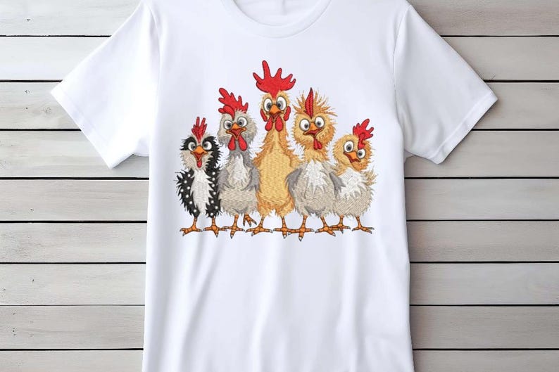 A white t-shirt with a graphic design of five cartoon chickens with red combs and wattles on their heads.
