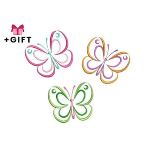 May include: Three embroidered butterfly designs in pink, green, and orange with purple accents. The butterflies have a delicate, open-wing design. A pink gift box with a bow and the text "+GIFT" is in the upper left corner.