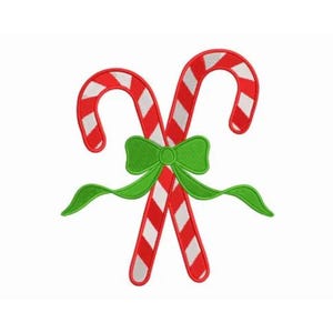 May include: Two embroidered candy canes with red and white stripes are crossed and tied with a green bow. The candy canes are a classic Christmas decoration, perfect for holiday crafts and decor.