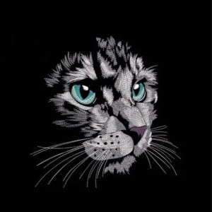 May include: Embroidered cat face with striking teal eyes and a black background. The cat's fur is detailed with white and gray thread, creating a textured effect. The nose is a soft purple, and long white whiskers extend from the face.