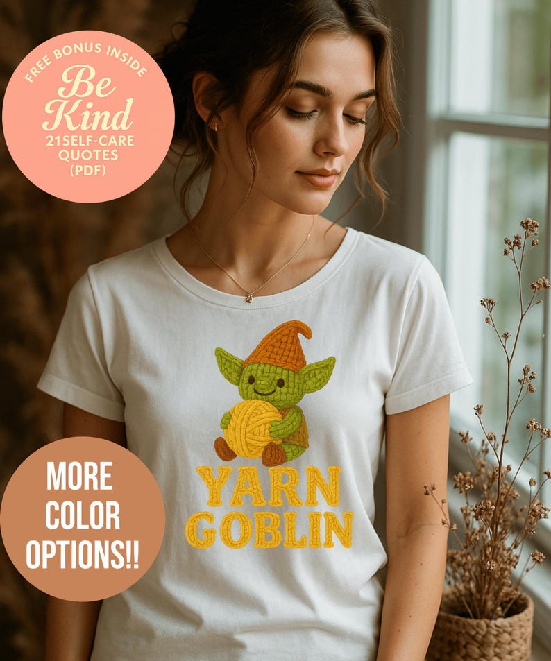 May include: White t-shirt featuring a cartoon goblin holding yarn, with the text "YARN GOBLIN" in yellow. The shirt also has a circular graphic with the text "Be Kind" and "21 SELF-CARE QUOTES (PDF)". A second graphic says "MORE COLOR OPTIONS!!".