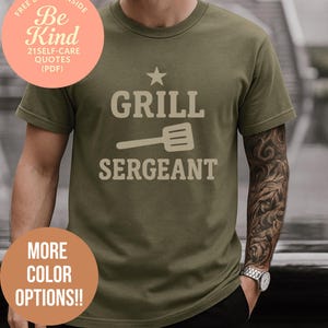 May include: Khaki green t-shirt with the words "GRILL SERGEANT" in a light tan hue, accompanied by a star and spatula graphic. The shirt also displays "MORE COLOR OPTIONS!!" and "FREE BONUS INSIDE Be Kind 21 SELF-CARE QUOTES (PDF)".