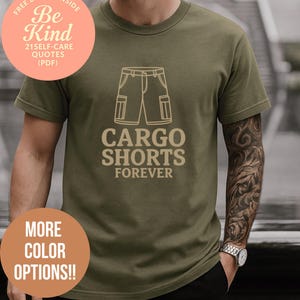 May include: Olive green t-shirt with a cargo shorts graphic and the text "CARGO SHORTS FOREVER." Additional text includes "FREE BONUS INSIDE Be Kind 21 SELF-CARE QUOTES (PDF)" and "MORE COLOR OPTIONS!!"