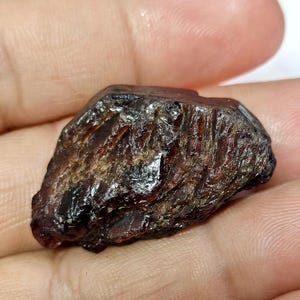 May include: A white ceramic mug with a black handle and the text "But First, Coffee" in a bold, black font. The mug is set against a blurred background, suggesting a cozy setting.