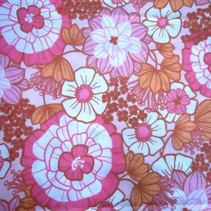 May include: A pink and white floral fabric with a retro 70s design. The fabric features large and small flowers in shades of pink, white, and orange.