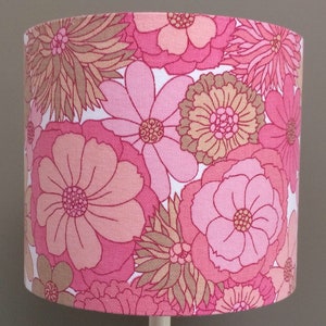 May include: A pink and brown floral lampshade with a white background. The lampshade has a large, bold floral pattern with pink and brown flowers.