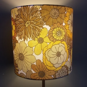 May include: A yellow and brown floral lampshade with a vintage design.
