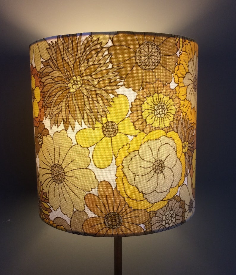 May include: A yellow and brown floral lampshade with a vintage design.