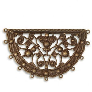 May include: A half-circle metal pendant with a decorative filigree design. The pendant has a textured surface and is made of brass.