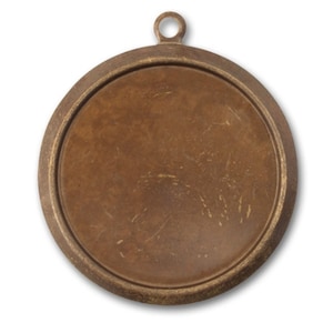May include: A round, bronze-colored pendant blank with a loop at the top for a chain. The pendant has a raised edge and a flat, circular center. The surface shows subtle scratches, giving it a vintage appearance. Ideal for jewelry making.