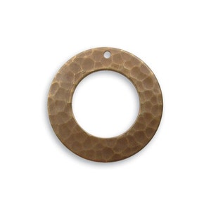May include: A hammered brass circle pendant with a hole in the top for hanging. The pendant has a smooth, textured surface and a circular opening in the center.