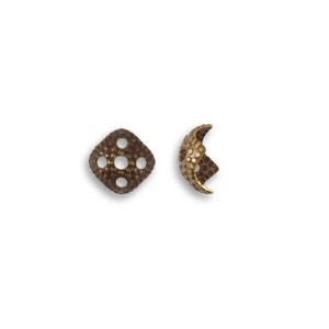 May include: Two antique bronze-colored metal bead caps. One is a flat, diamond-shaped cap with five holes. The other is a curved cap with a textured, dimpled surface, showcasing a detailed design for jewelry making.