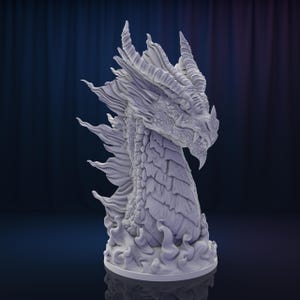 Könnte beinhalten: Eine weiße, detaillierte Drachenkopfskulptur mit einer strukturierten, schuppigen Oberfläche. Der Drachenkopf ist zur Seite geneigt und sein Maul ist leicht geöffnet, wodurch scharfe Zähne sichtbar werden. Die Skulptur steht auf einem Sockel mit einem wirbelnden, flammenartigen Design.