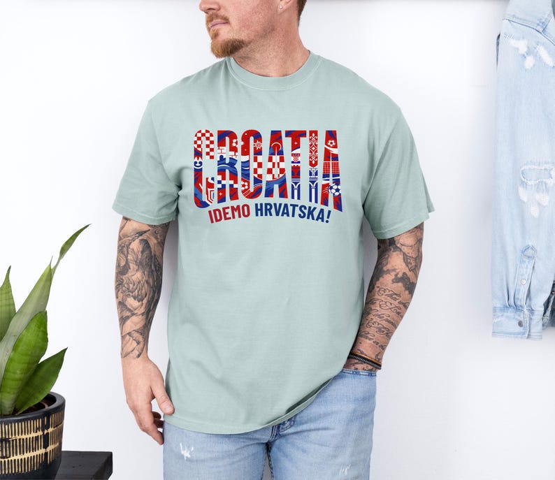 May include: A light green t-shirt with the word "CROATIA" in red, white, and blue, with various Croatian flag-inspired designs. Below the word is the text "IDEMO HRVATSKA!"
