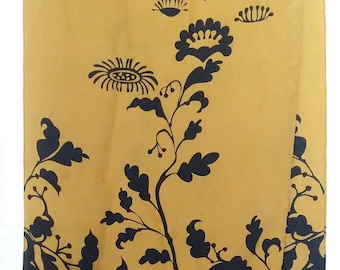 May include: A long, rectangular scarf with a floral design. The top and bottom sections are navy blue, while the center is a golden yellow. The floral pattern is in navy blue and features stylized flowers and foliage.