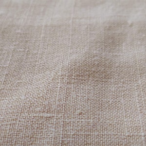 May include: Close-up of a beige linen fabric with a woven texture.