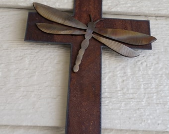 Croce in metallo rustico con libellula iridescente. Arte murale personalizzata in acciaio riciclato.