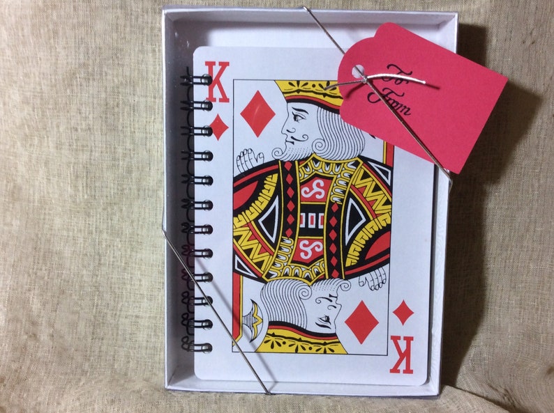 5 x 7 playing card notebooks come boxed with a clear lid and to/from tag on a stretch cord.  the 8 x 11 playing card notebooks come in a clear cellophane sleeve with to/from tag.